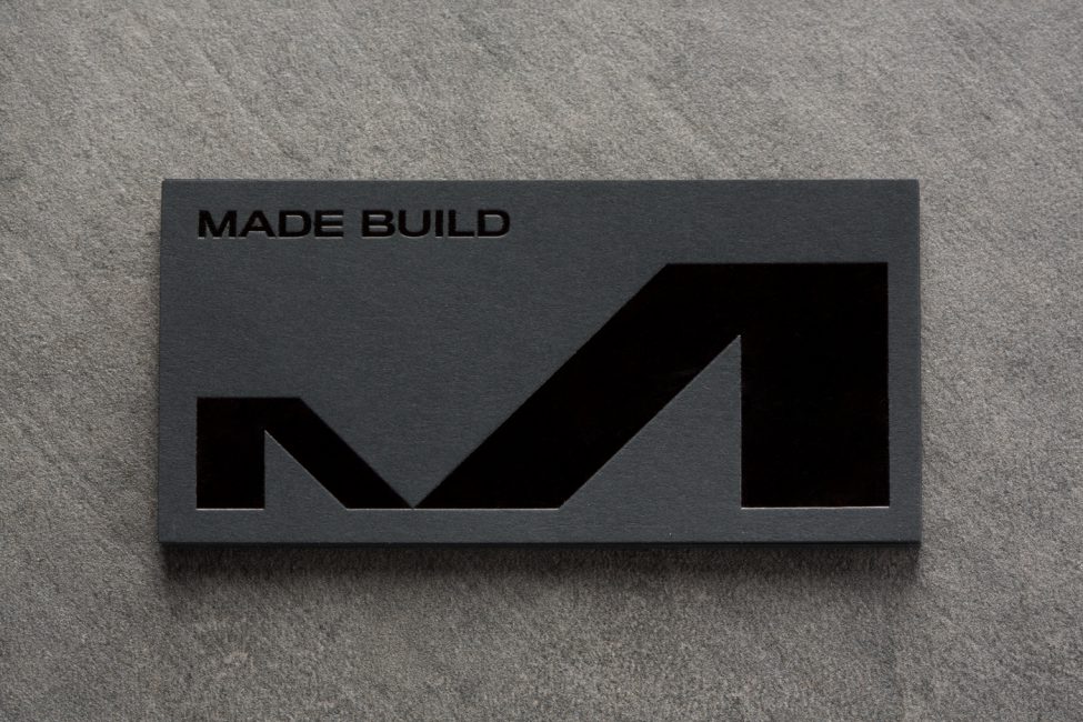 Made Build business card in dark grey and black logo